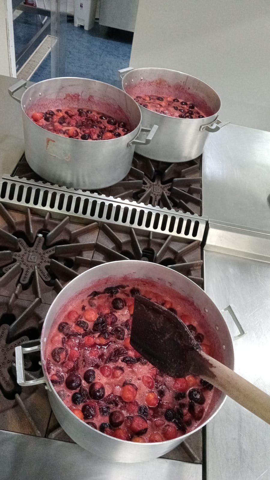 Ollas con cerezas y frambuesas cocinándose
